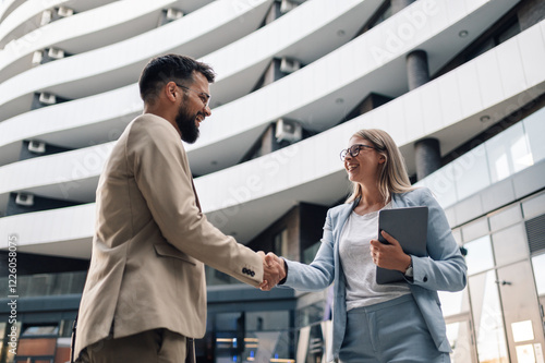 Cuadro en lienzo Business people shaking hands in front of modern office building