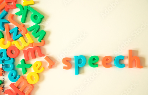 Speech word over warm white background formed from a bunch of scattered English Latin alphabet letters types. Oral communication, talk, speech therapy, expression and language concepts.