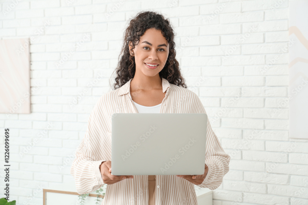 Pretty young African-American woman with laptop at home Pretty young African-American woman with laptop at home