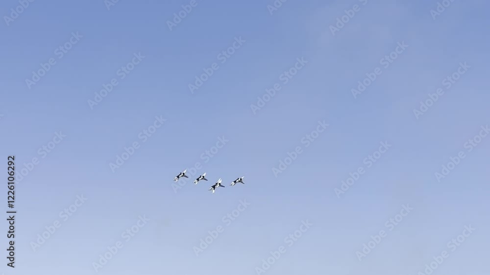 Group of four military fighter jets soaring in tight formation through a clear blue sky, showcasing aerial precision and teamwork, concept of aviation, power, and skill. Group of four military fighter jets soaring in tight formation through a clear blue sky, showcasing aerial precision and teamwork, concept of aviation, power, and skill.