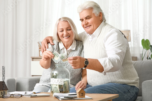 Senior couple putting money...