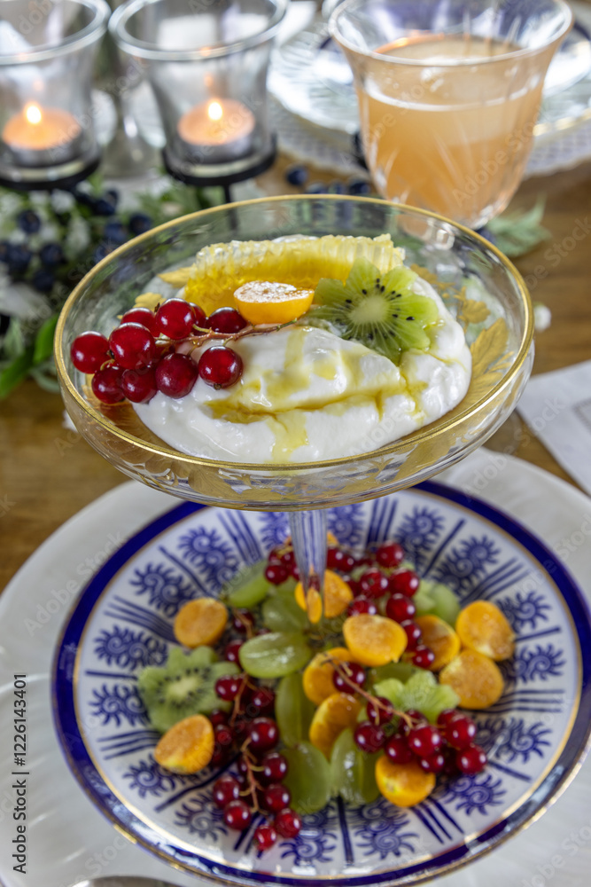 Fruit and Greek Yogurt breakfast with a slice of honey comb and golden berries Fruit and Greek Yogurt breakfast with a slice of honey comb and golden berries
