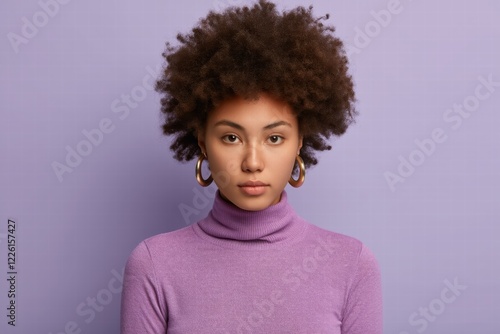 A female model with afro hair in a studio, showing off beauty, fun and fashion with a mix of expressions including joy and concern. photo