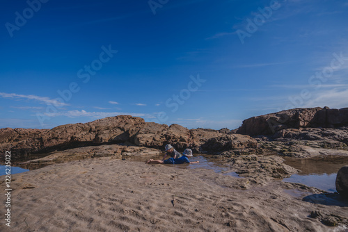 Two kids playing in rock pools