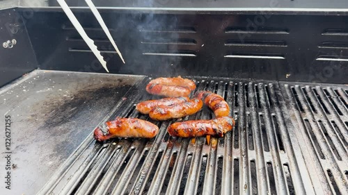 Grilling Cheese Kransky Sausages on BBQ photo