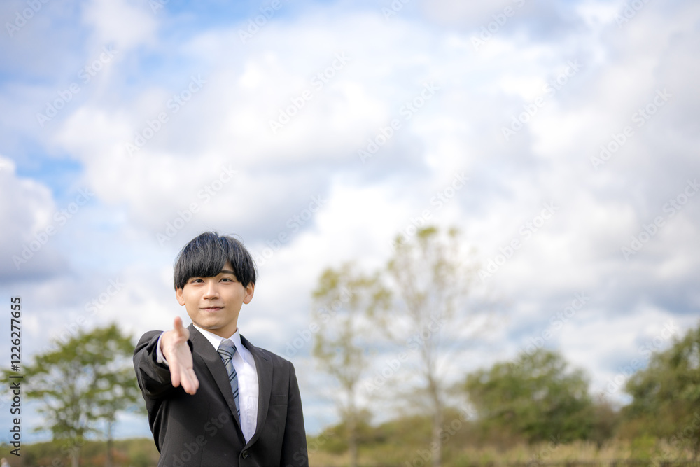 握手を求めるビジネスマンと青空