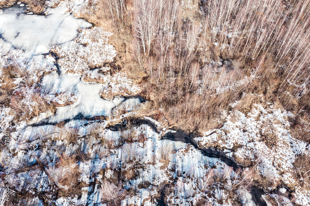 aerial view of snow-covered forest swamp at bright sunny spring day. drone photo. aerial view of snow-covered forest swamp at bright sunny spring day. drone photo.