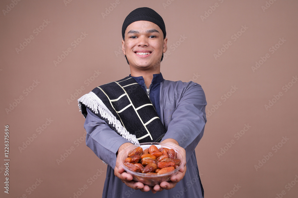 Portrait Of Young Asian Muslim Guy Giving Dates Fruit For Breakfasting On Beige Studio Wall
Portrait Of Young Asian Muslim Guy Giving Dates Fruit For Breakfasting On Beige Studio Wall