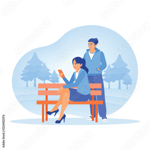 Two people on a park bench looking at a cell phone together.