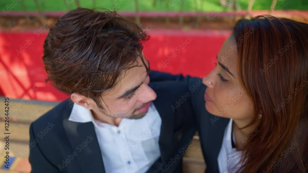 Lovers sits holding hands talking passionately in garden Lovers sits holding hands talking passionately in garden
