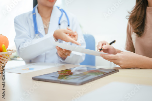 A young female nutritionist expert talks to a female patient at a table, recommending a healthy diet with vegetables and fruits to promote wellness, balanced nutrition, and effective weight loss photo