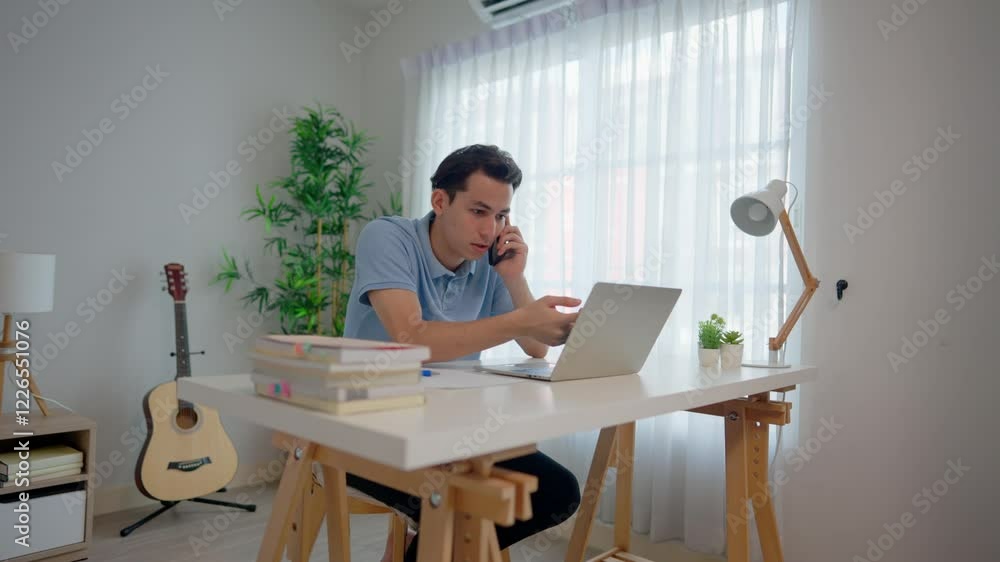 Asian upset depressed man talking on mobile phone in living room at home. Asian upset depressed man talking on mobile phone in living room at home.
