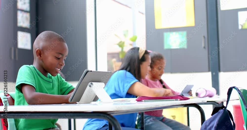 In school, children using tablets and working together in classroom In school, children using tablets and working together in classroom