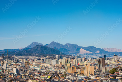 大分市市街地と遠くに見える鶴見岳と由布岳の風景