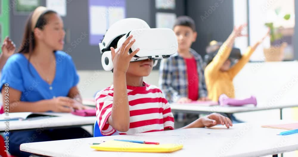In school, boy using VR headset in classroom with teacher and students In school, boy using VR headset in classroom with teacher and students