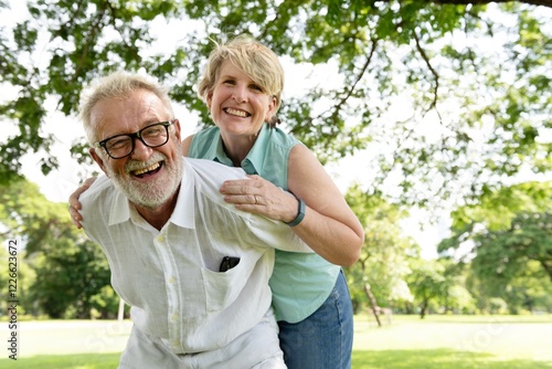 Canvas Print Elderly couple enjoying a sunny day in park