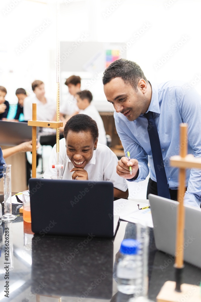 Fototapeta premium Teacher and student in a science class. Male teacher, female student. Engaged in learning, science experiment, and computer work. Classroom setting, diverse group. Students and education concept.