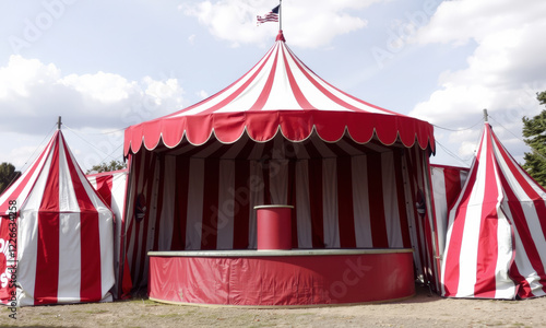 vibrant vintage circus tent with red and white stripes, featuring central stage and smaller tents, evokes sense of nostalgia and excitement photo