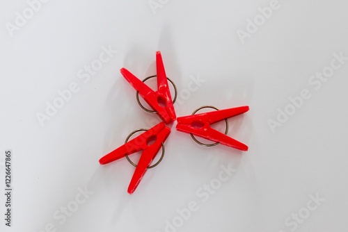 Three red clothes pegs on a white background photo