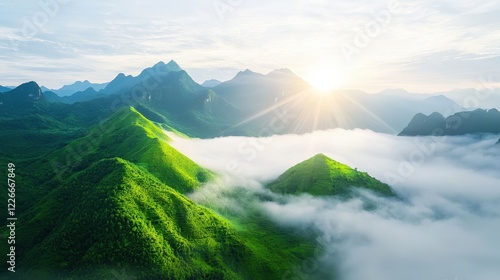Misty mountain landscape at dawn with green valley and soft fog rolling over hills in the background