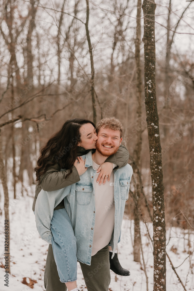 A happy couple enjoying a snowy day in a winter forest A happy couple enjoying a snowy day in a winter forest