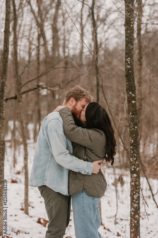 A happy couple enjoying a snowy day in a winter forest A happy couple enjoying a snowy day in a winter forest
