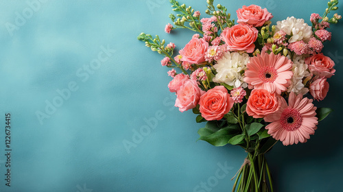 A vibrant bouquet featuring pink roses, gerberas, and seasonal blooms, elegantly tied with a ribbon on a blue background. Festive banner for Valentine's Day, birthday, mother's day. Copy space.Mock up