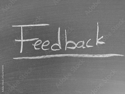 Feedback written on a dark chalkboard in white chalk with underlined text photo