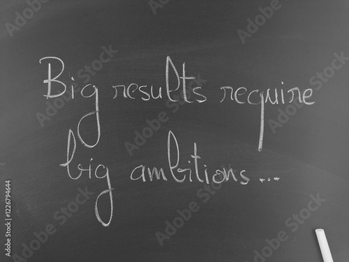 Big results require big ambitions handwritten on a chalkboard in monochrome
