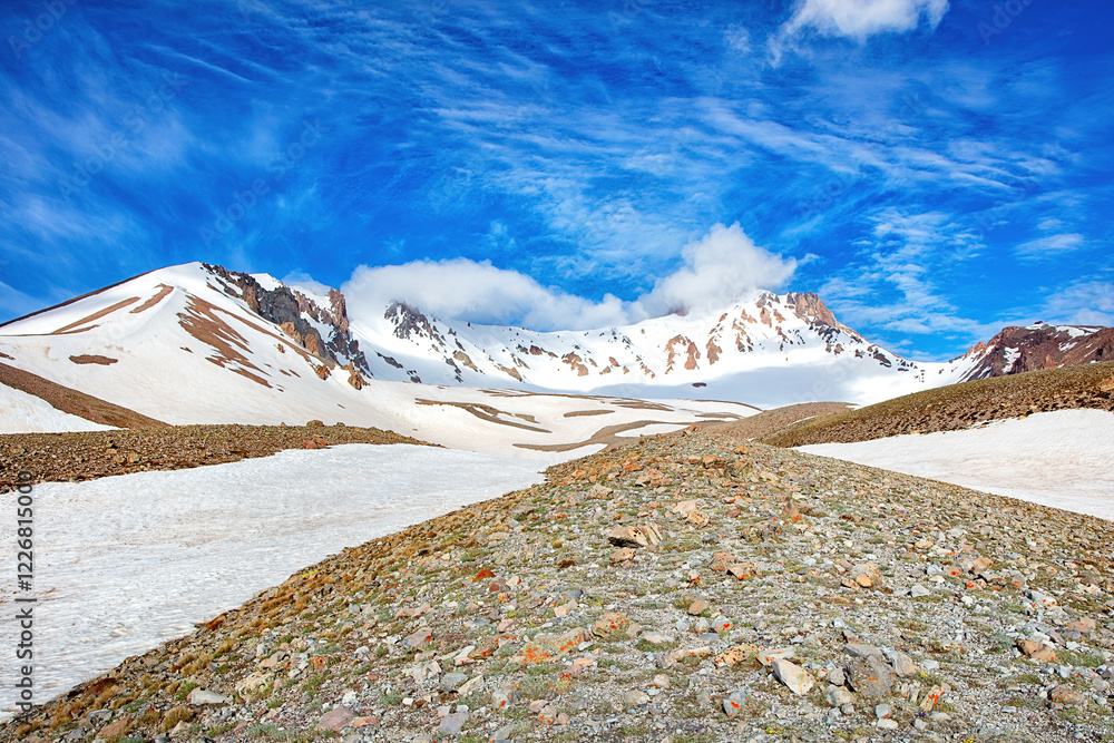 Majestic snow-capped mountains under a brilliant blue sky at midday in a tranquil landscape
