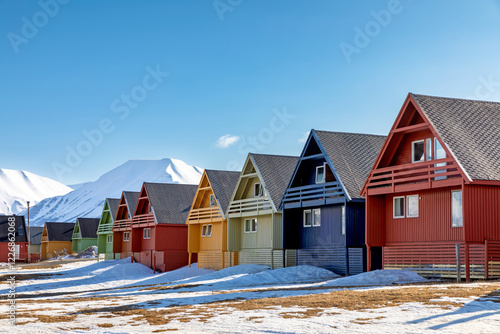 Row of colourful wooden houses in Longyearbyen, Svalbard, the most northerly town in the world. Early spring scene with snow on the mountains and the foreground