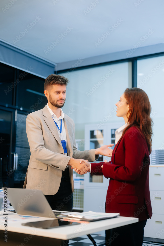 Fototapeta premium Business colleagues shaking hands in a corporate office, symbolizing partnership, teamwork