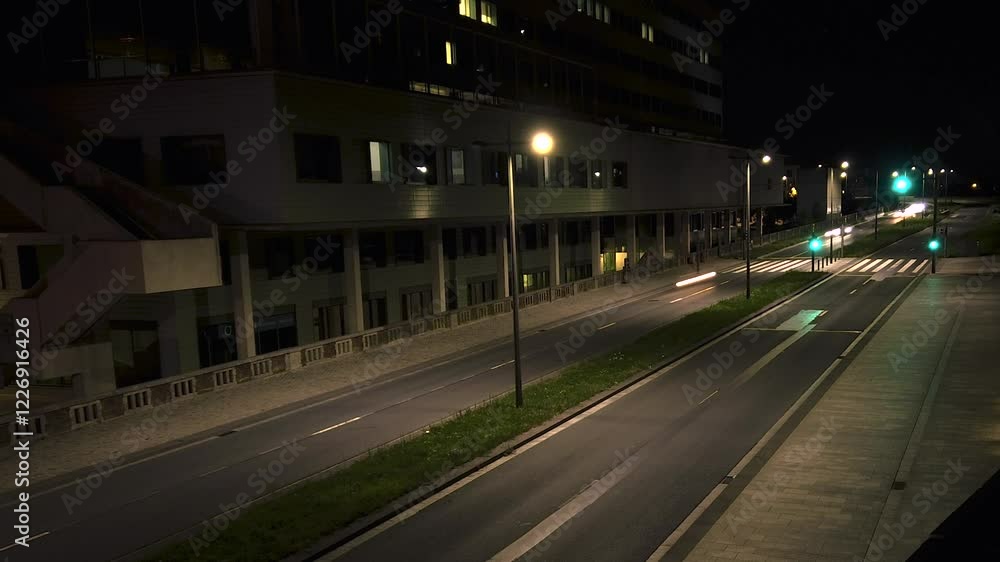Nighttime timelapse capturing the vivid trails of car lights moving in both directions along an urban street, highlighting the rhythmic flow of city traffic Nighttime timelapse capturing the vivid trails of car lights moving in both directions along an urban street, highlighting the rhythmic flow of city traffic