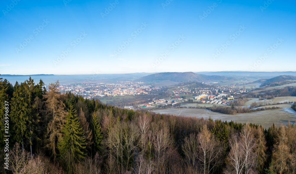 Aerial view of Moravska Trebova with its scenic panorama. The town is surrounded by rolling hills and dense forests, showcasing the harmony of historic architecture and Czech nature