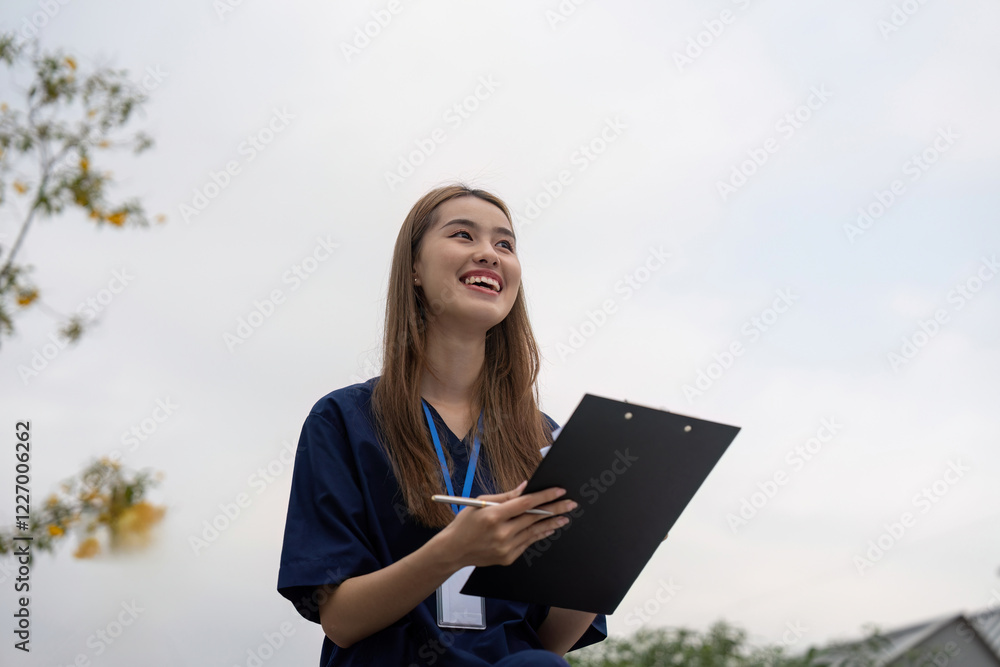 Nurse smiling while reviewing patient notes on a clipboard during a break Nurse smiling while reviewing patient notes on a clipboard during a break