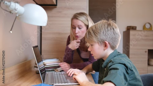 A mother, helping her son with his homework. They are using a laptop to search for information and solve tasks together.