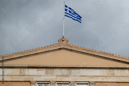 Flag of Greece on top of Hellenic Parliament in the Old Royal Palace, overlooking Syntagma Square in Athens, Greece photo