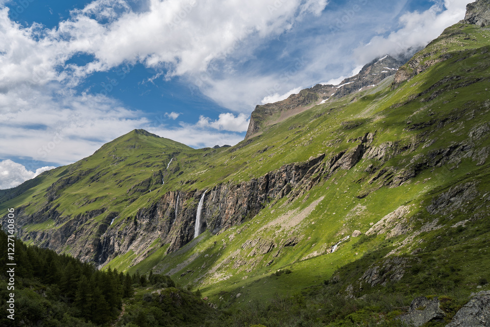 Witness the breathtaking beauty of the French Alps with this stunning photograph taken in Savoie. The image captures a dramatic mountainous landscape featuring lush green slopes and rugged rocky cliff Witness the breathtaking beauty of the French Alps with this stunning photograph taken in Savoie. The image captures a dramatic mountainous landscape featuring lush green slopes and rugged rocky cliff