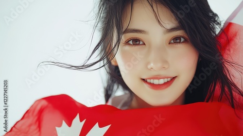 Happy young Asian woman with a Canadian flag on a white background