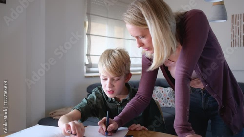 A mother, helping her son with his homework. They are using a laptop to search for information and solve tasks together.
