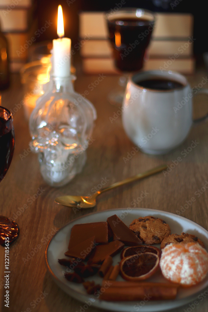 Books, lit candles, red wine, snacks and various deocration on the table. Dark academia or Halloween concept. Selective focus. Books, lit candles, red wine, snacks and various deocration on the table. Dark academia or Halloween concept. Selective focus.