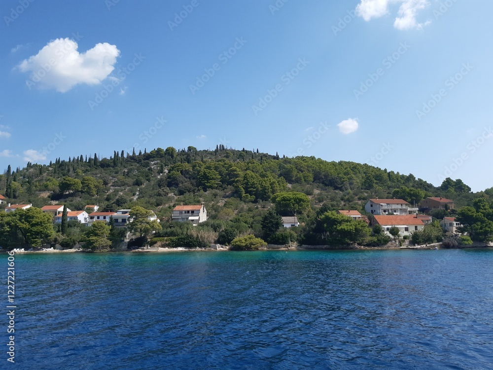 The beautiful view onto an old classical Croatian village from a small ship The beautiful view onto an old classical Croatian village from a small ship