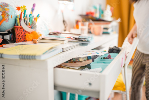 Mess in a desk drawer. Table organization concept. House cleaning themed photo.