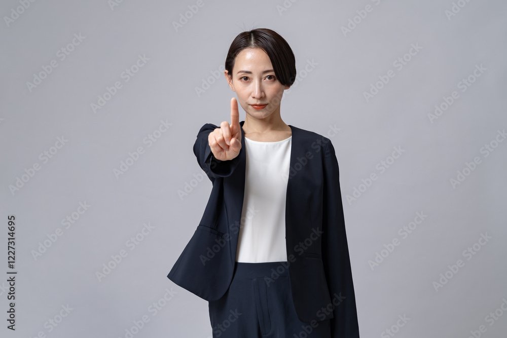 指差しをするスーツを着た女性