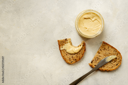 Jar of coconut butter cream and multigrain bread. Sugar and lactose free breakfast photo