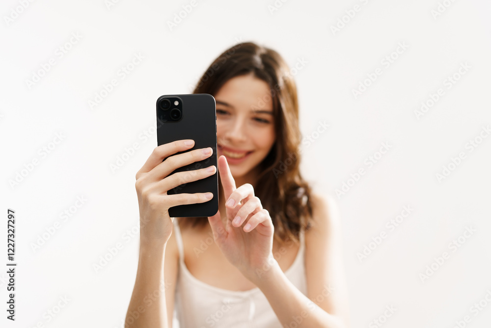 Young brunette woman in a white light top posing against a white background, expressing emotions and touching her face with her hands. Minimalistic and natural beauty concept Young brunette woman in a white light top posing against a white background, expressing emotions and touching her face with her hands. Minimalistic and natural beauty concept