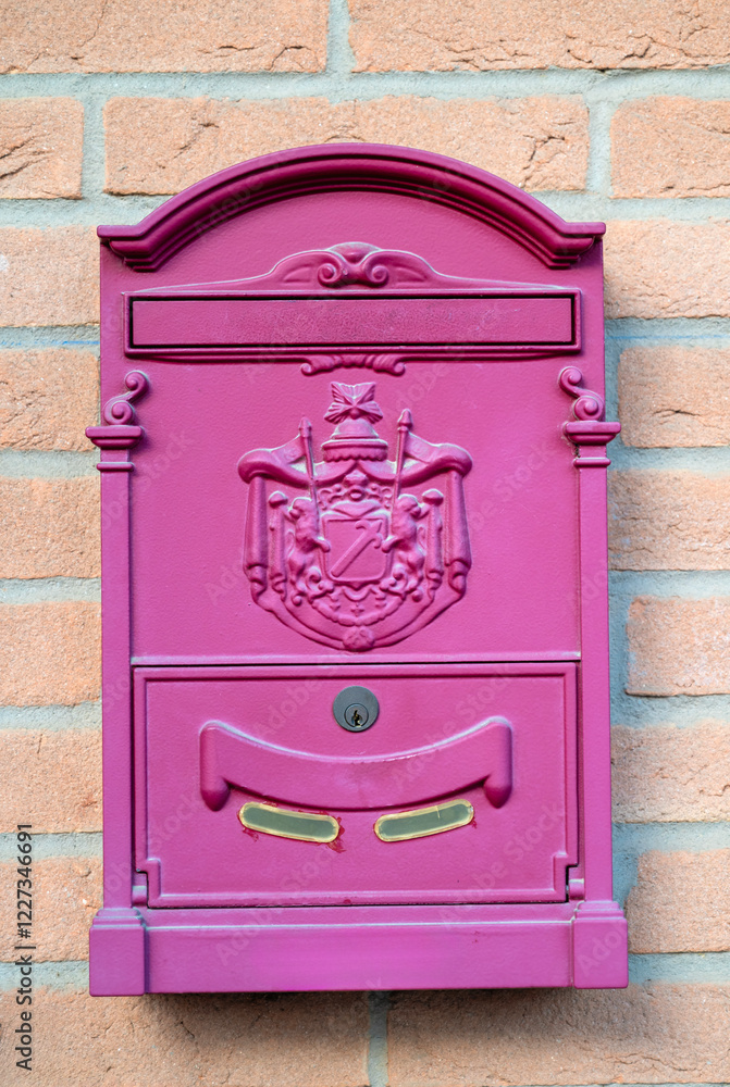 Pink metal postcard mailbox on brick wall Pink metal postcard mailbox on brick wall