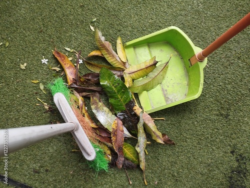 Φωτογραφία Close up cleaning or sweeping fallen and dry leaves in the home garden using a broom stick, Cleaning housework concept