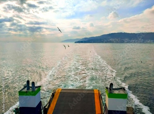 View of the sea, Dardanelles Strait, Gallipoli shores and flying seagulls from a ferry on a cloudy day. photo