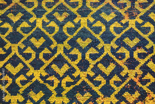 Traditional Turkish carpet texture with intricate geometric pattern in yellow and blue tones, detailed woven textile background photo